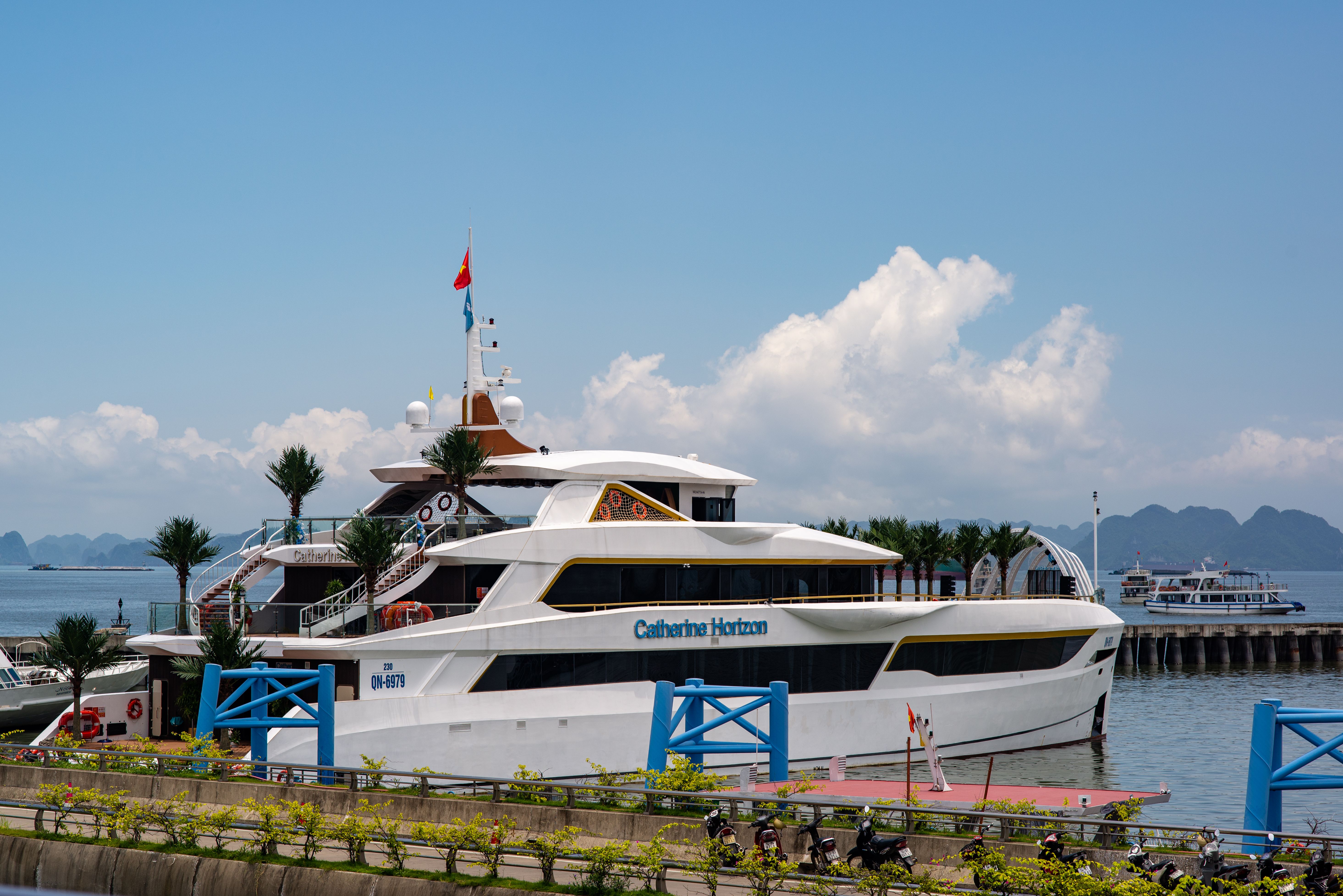 Stunning luxury yacht docked at Ha Long Bay marina, under blue skies.