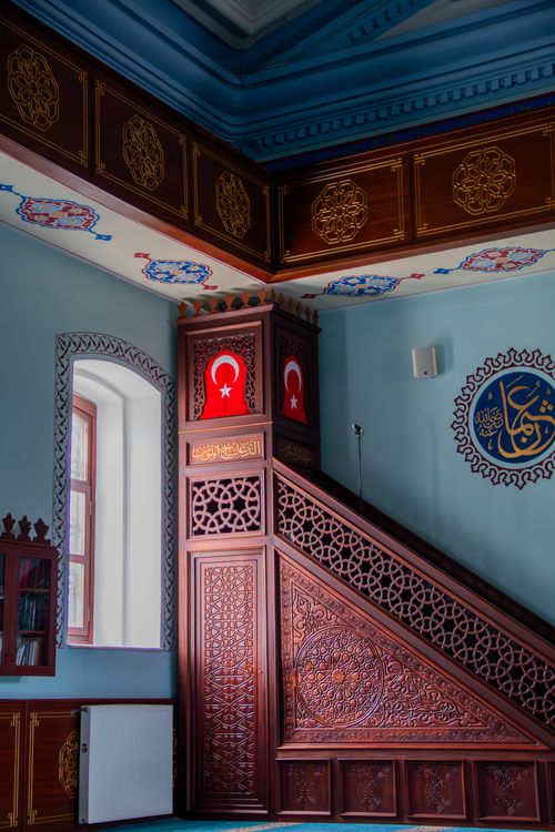 Free Captivating view of mosque interior with ornate woodwork and Turkish flags, located in Kars, Türkiye. Stock Photo