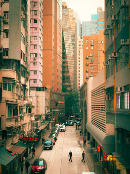 Vibrant city street in Hong Kong with skyscrapers and busy atmosphere, perfect for urban lifestyle themes.