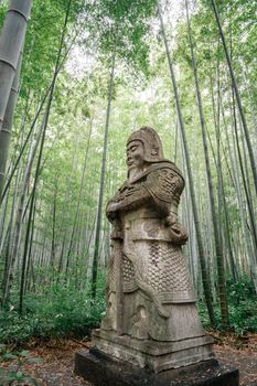 Stone guardian statue from the Ming Dynasty surrounded by bamboo in Nanjing, China.