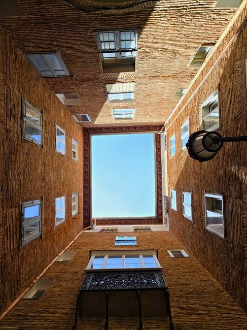View of blue sky framed by brick courtyard with historic architecture