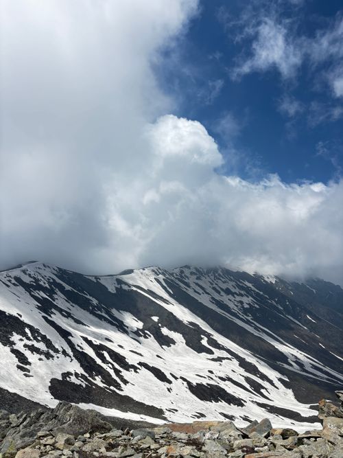 Free Stunning view of snow-covered mountains beneath dramatic cloud formations, showcasing pristine natural beauty. Stock Photo