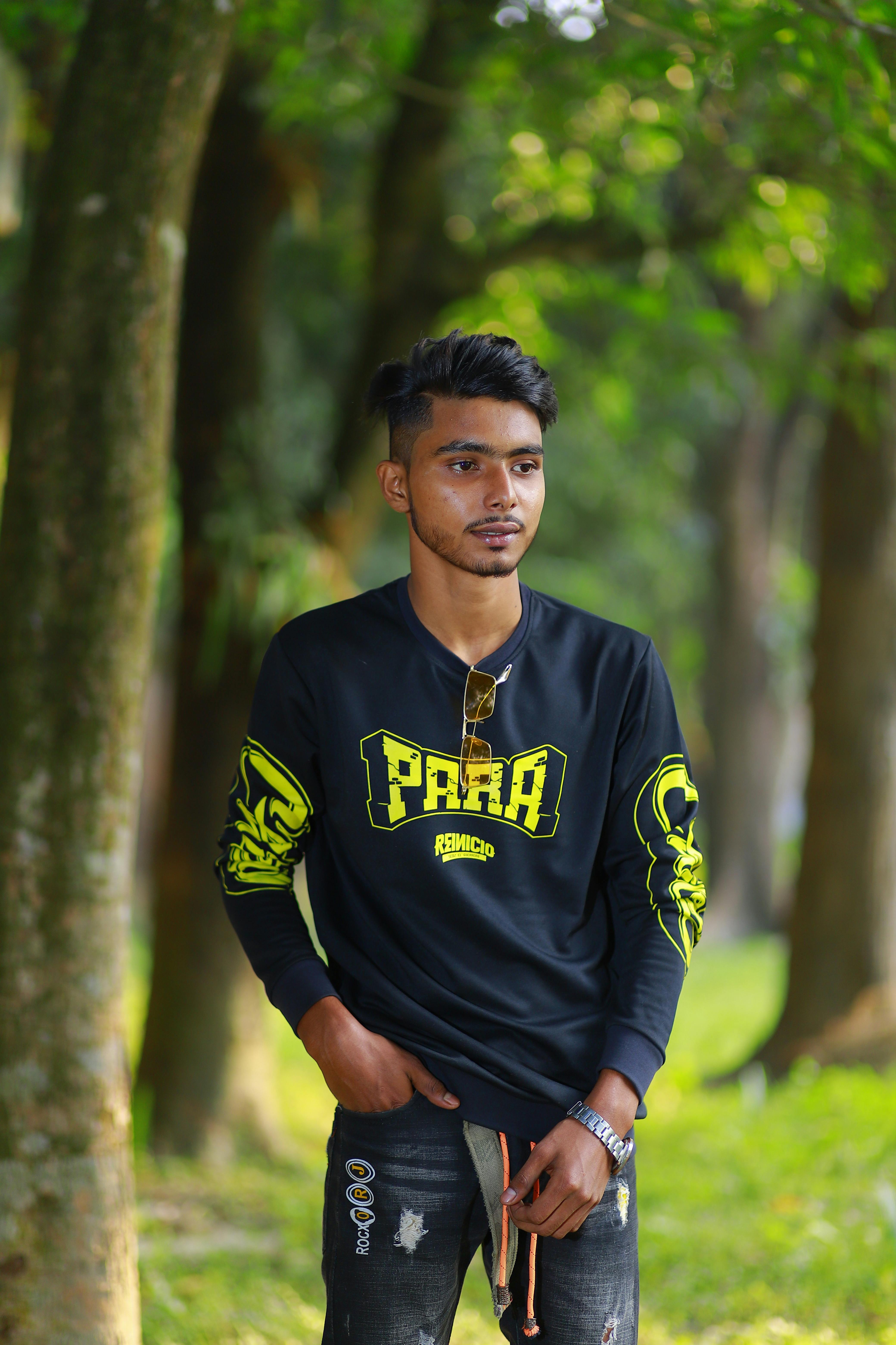 Portrait of a young man in a park in Brahmanbaria, Bangladesh, surrounded by greenery.