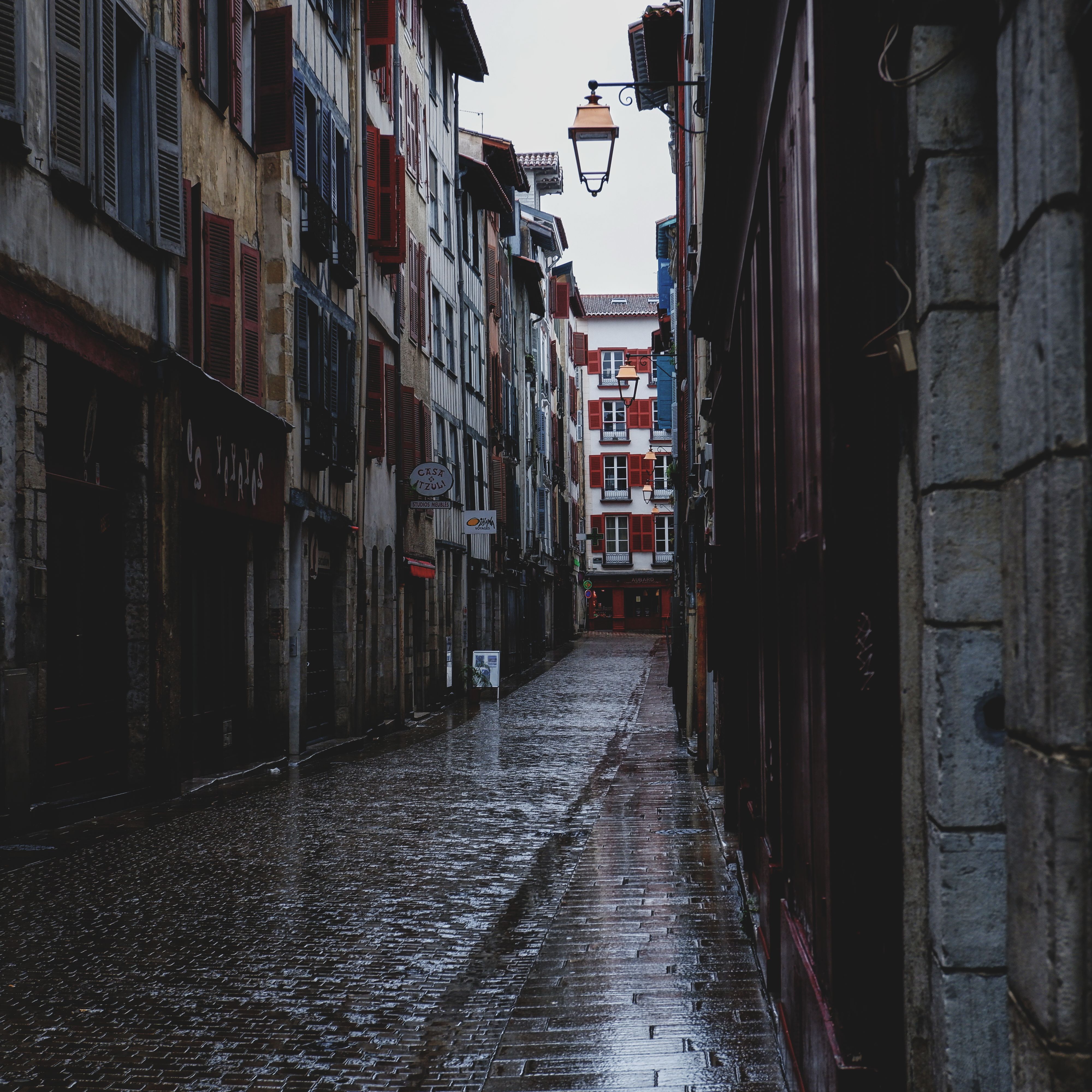 Explore the rainy charm of Bayonne's historic alleys, showcasing classic European architecture.
