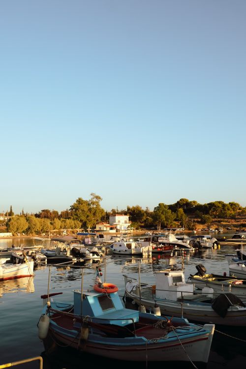 Free Peaceful scene of a marina with fishing boats in Greece during sunset. Stock Photo
