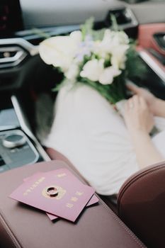 Wedding rings and bouquet inside a luxury car, capturing elegance and celebration.