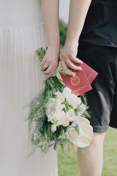 Romantic couple holding red envelopes and flowers, signifying a wedding celebration.