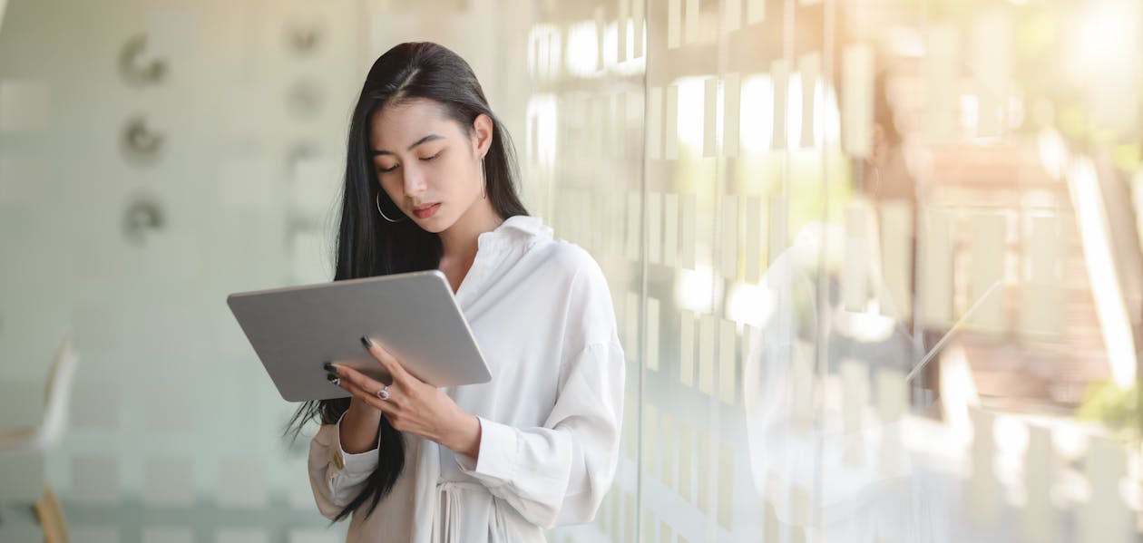 Woman in White Robe Holding White Tablet Computer