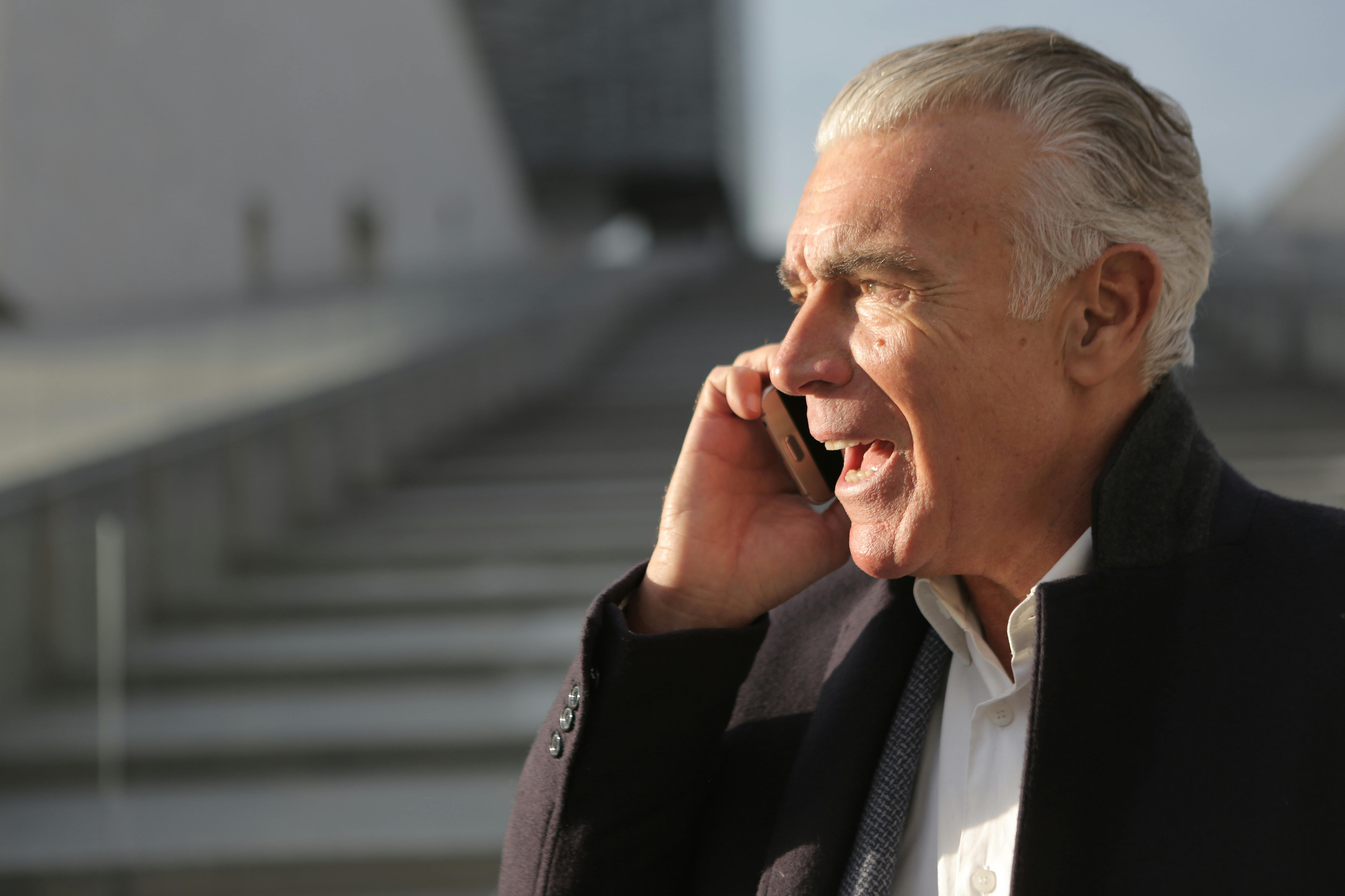 Man Sitting on Bench Using Mobile Phone · Free Stock Photo