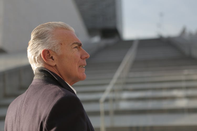 Serious Elderly Gentleman On Stone Stairs In City