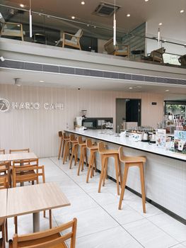 Contemporary café interior with wooden furniture and bar in Bangkok, Thailand.