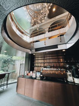 A sophisticated cafe interior in Bangkok featuring a stunning chandelier and modern design elements.