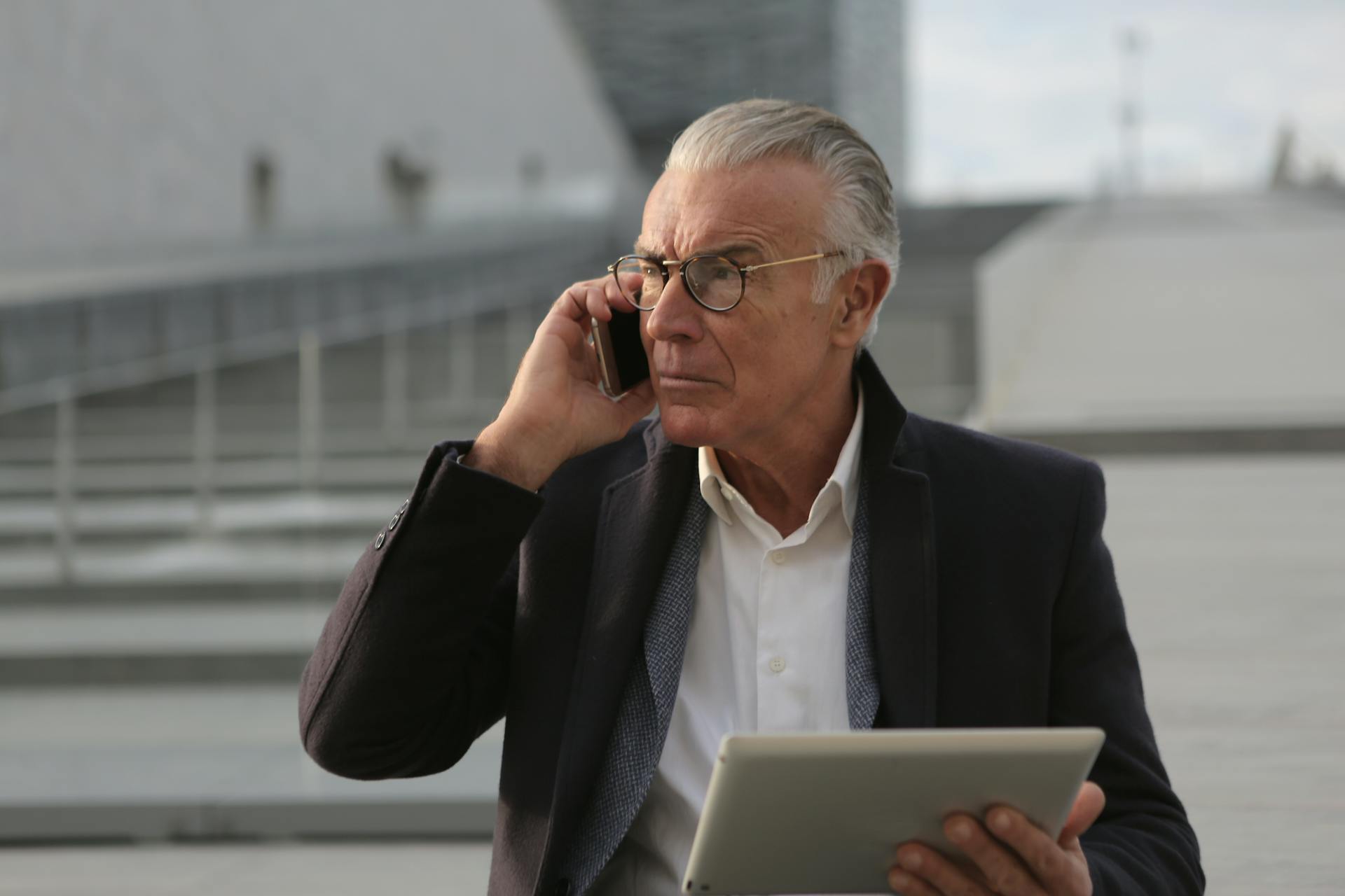 Man in Black Suit Jacket Using Smartphone