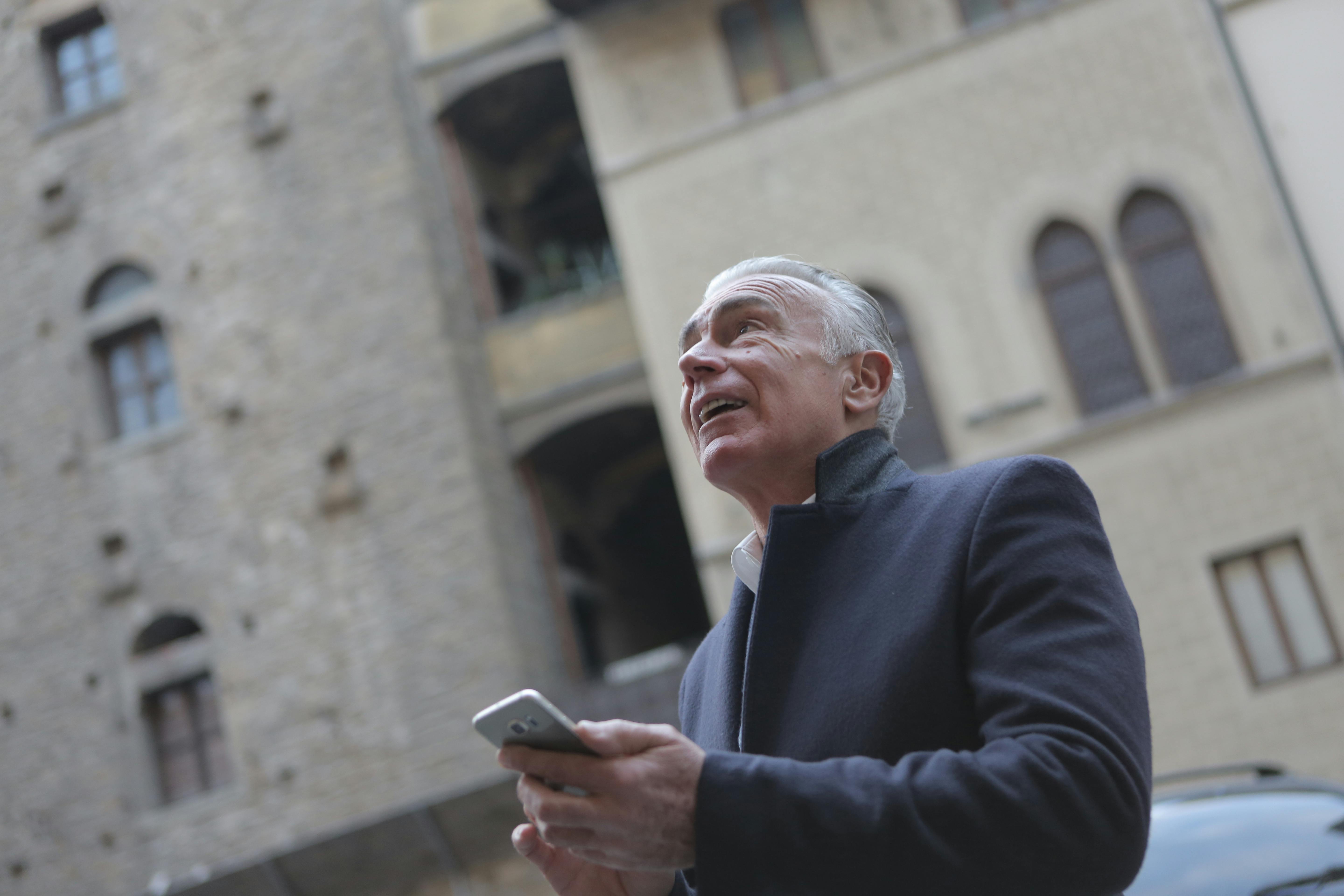 elegant senior man browsing smartphone on city street