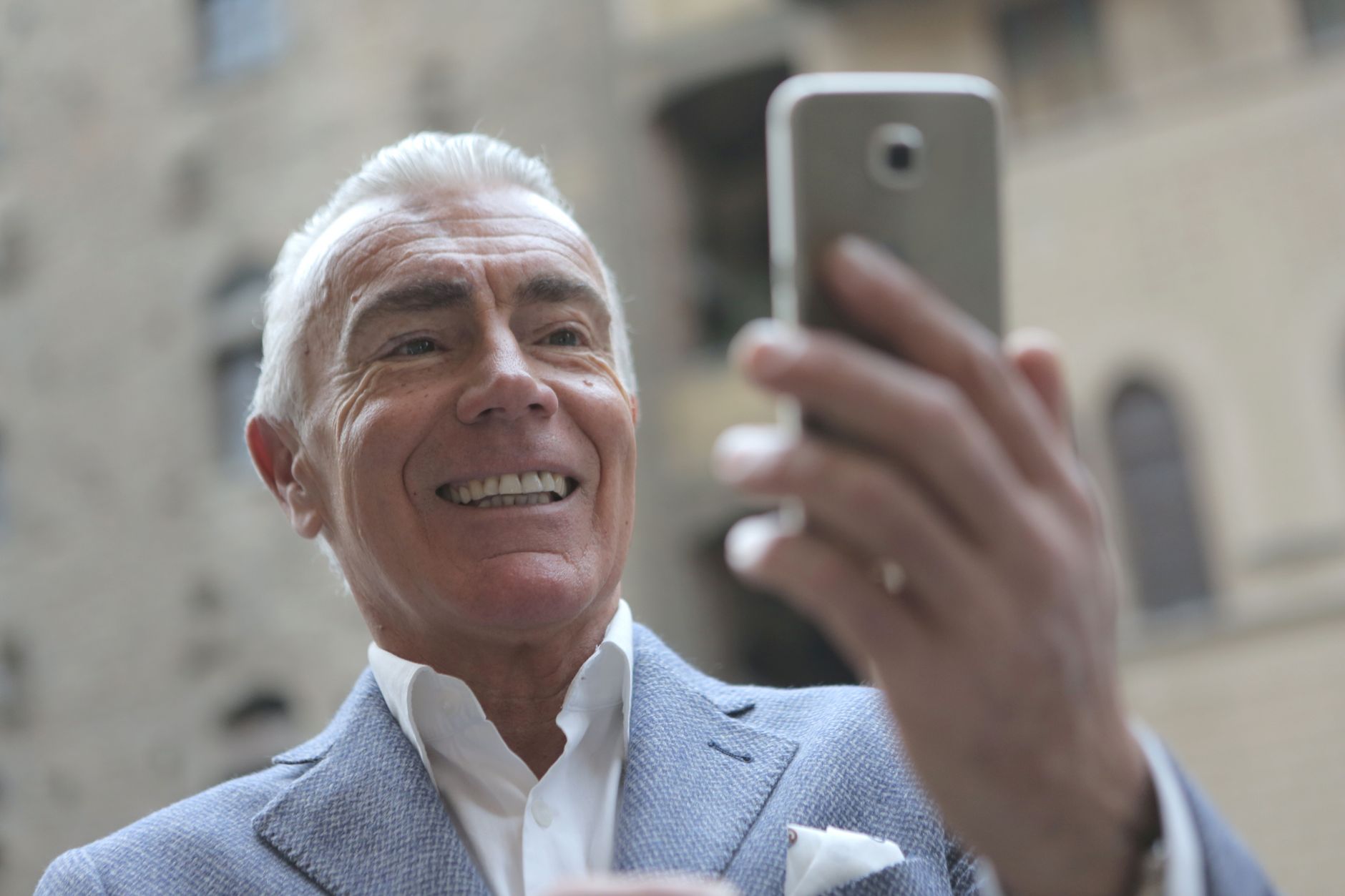 대전 어르신 스마트폰 무료 교육, 구청·평생교육원 신청처 이렇게 찾는다 6 Elderly man in a suit smiling while taking a selfie outside.