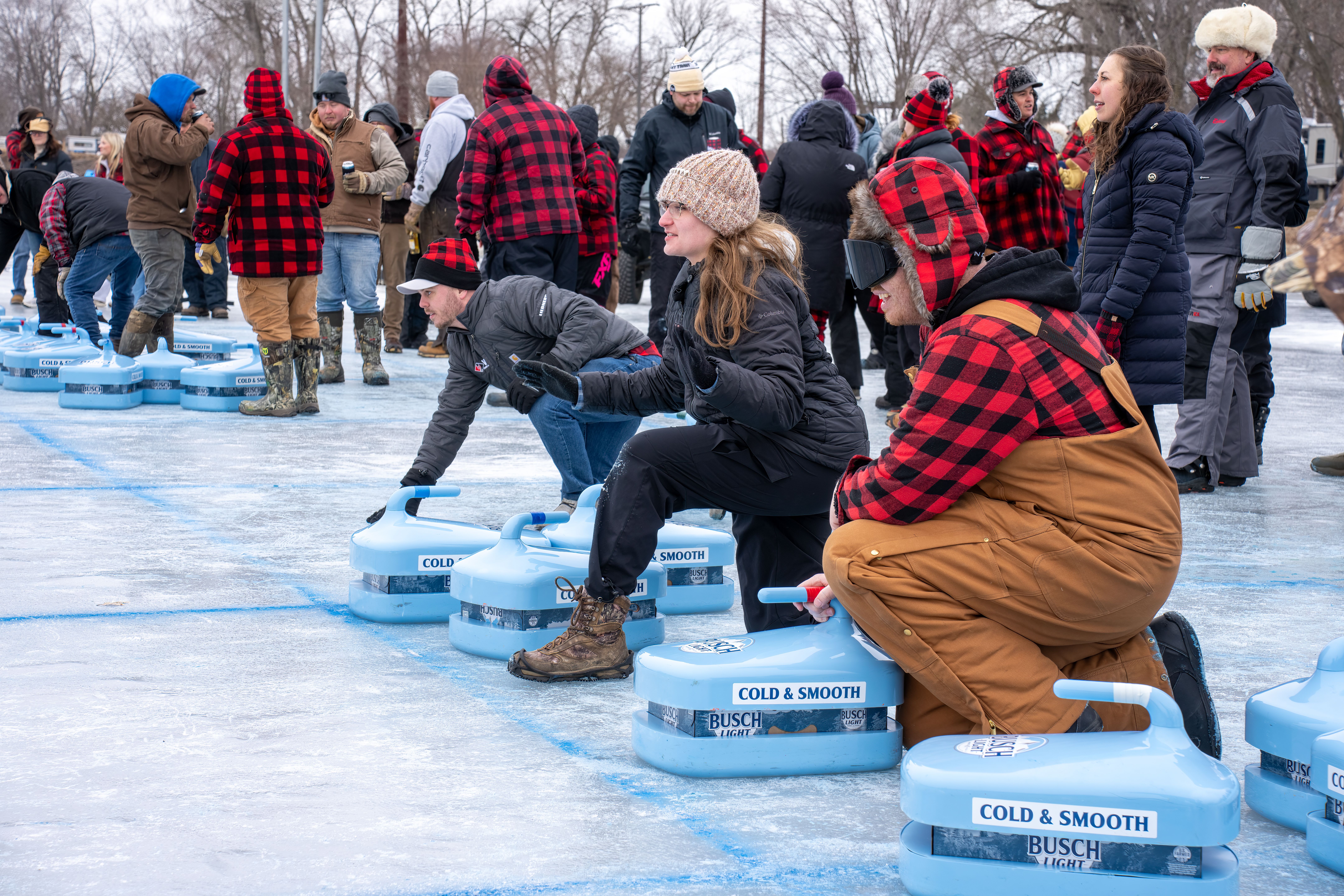 Participants in plaid jackets engage in an energetic ice bocce tournament at Wabasha, Minnesota.
