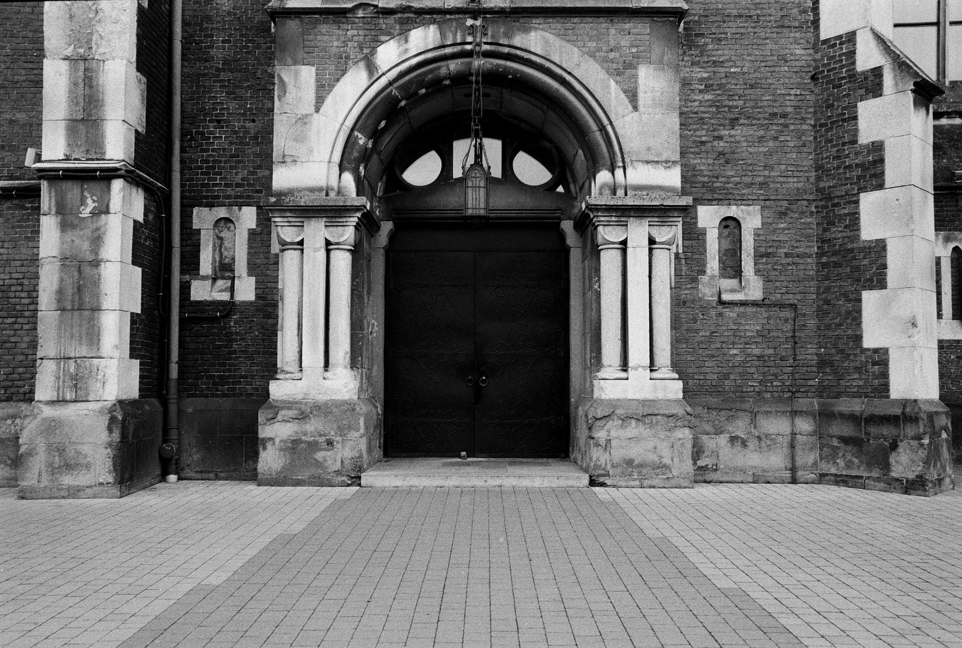 Black and white photo of a historic brick archway entrance in Lviv, Ukraine.
