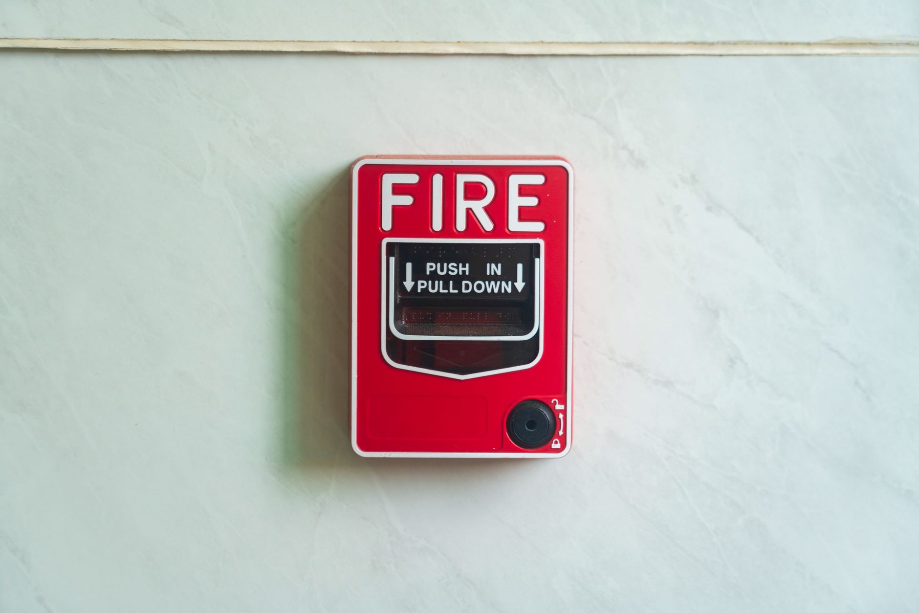 Image of a wall mounted red fire alarm device for safety alerts and emergency preparedness.