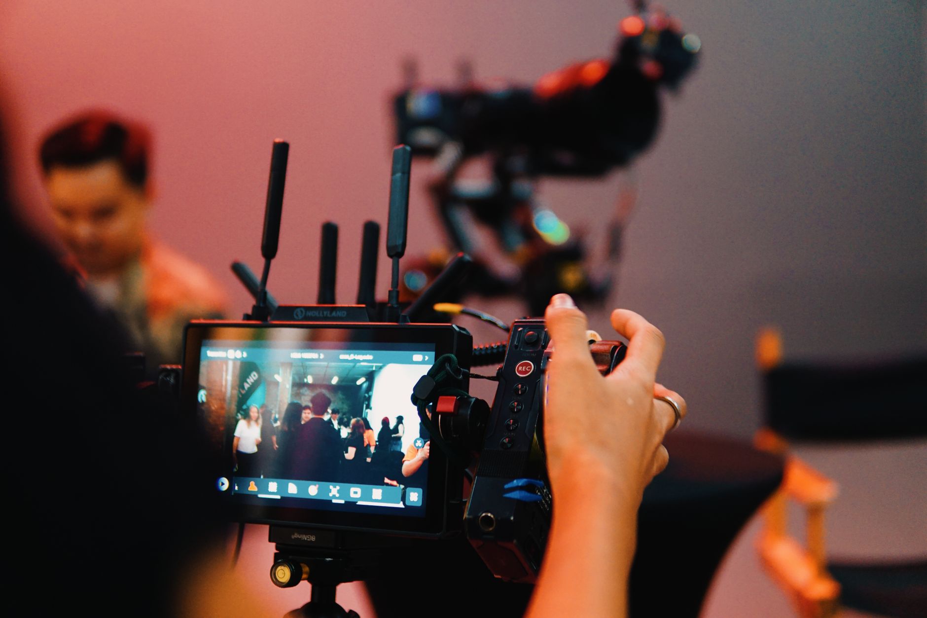 Close-up of a film monitor on set showing production staff and actor.