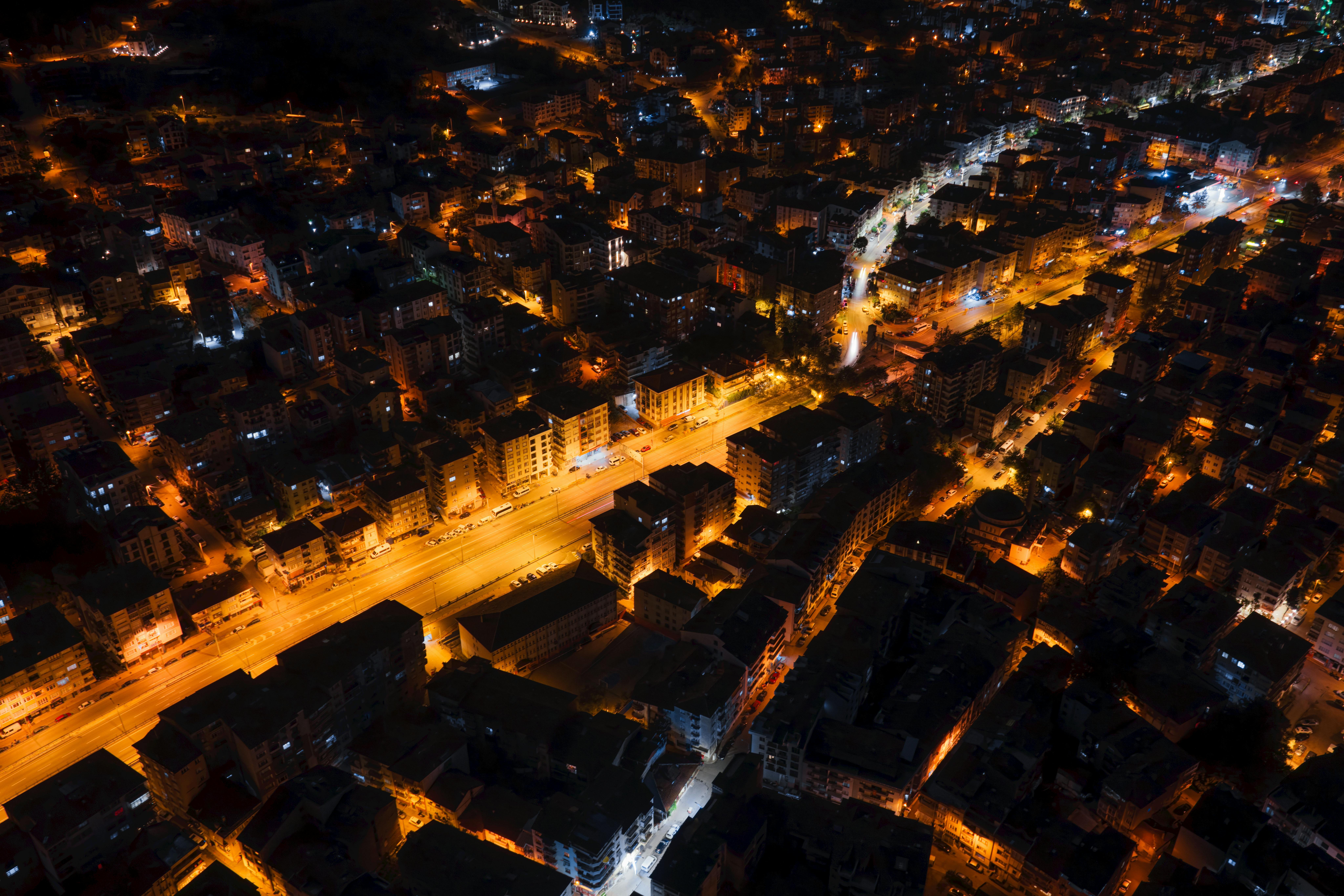 A captivating aerial view of city streets glowing with streetlights at night, showcasing urban life.