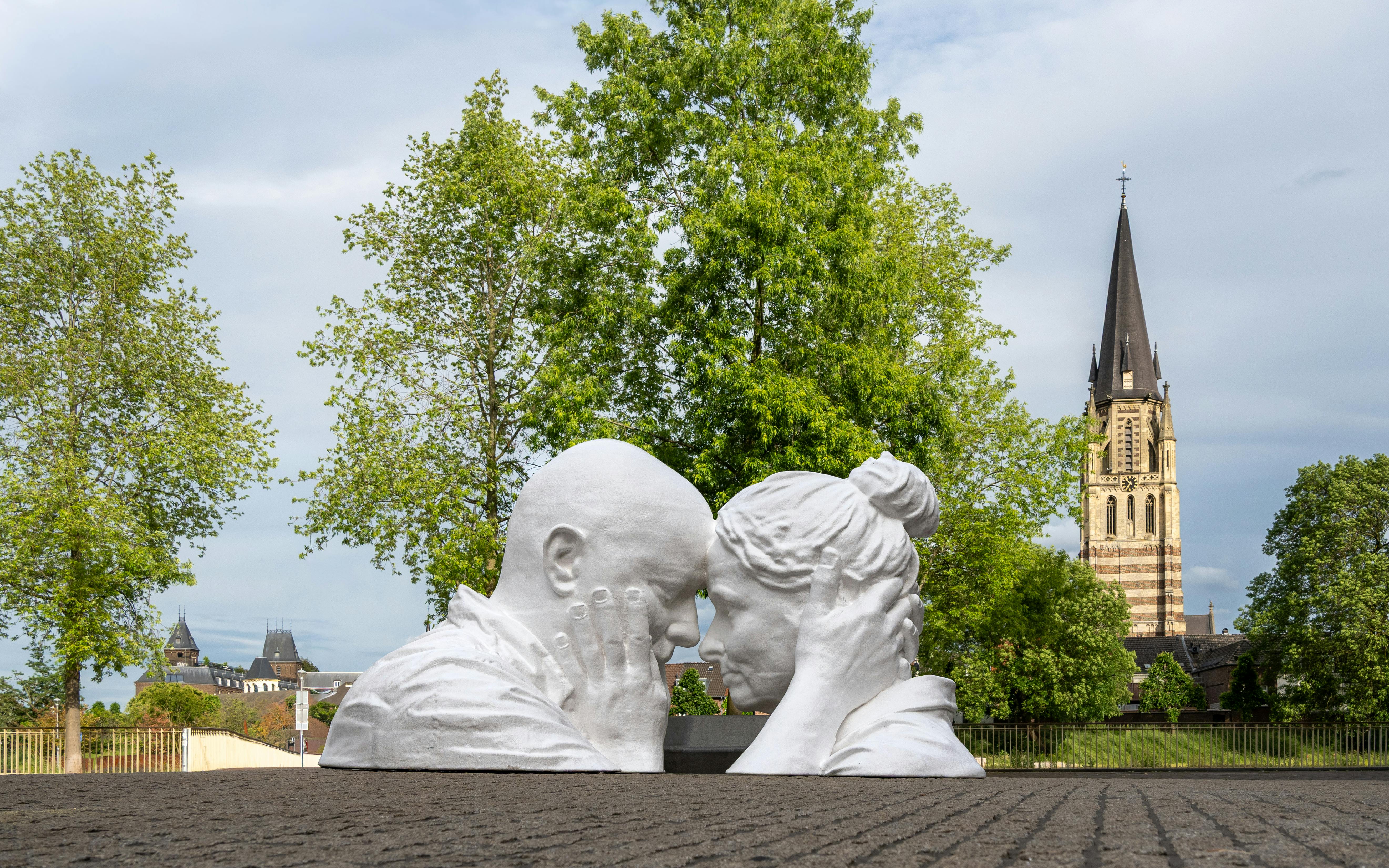 A romantic sculpture set against the historic architecture and lush greenery of Sittard, Limburg.