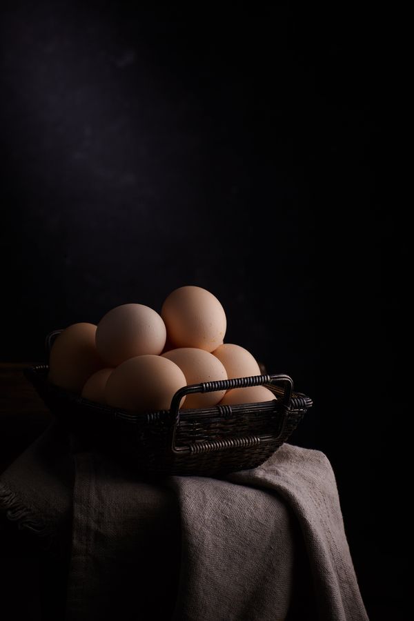 Fresh eggs resting in a rustic basket