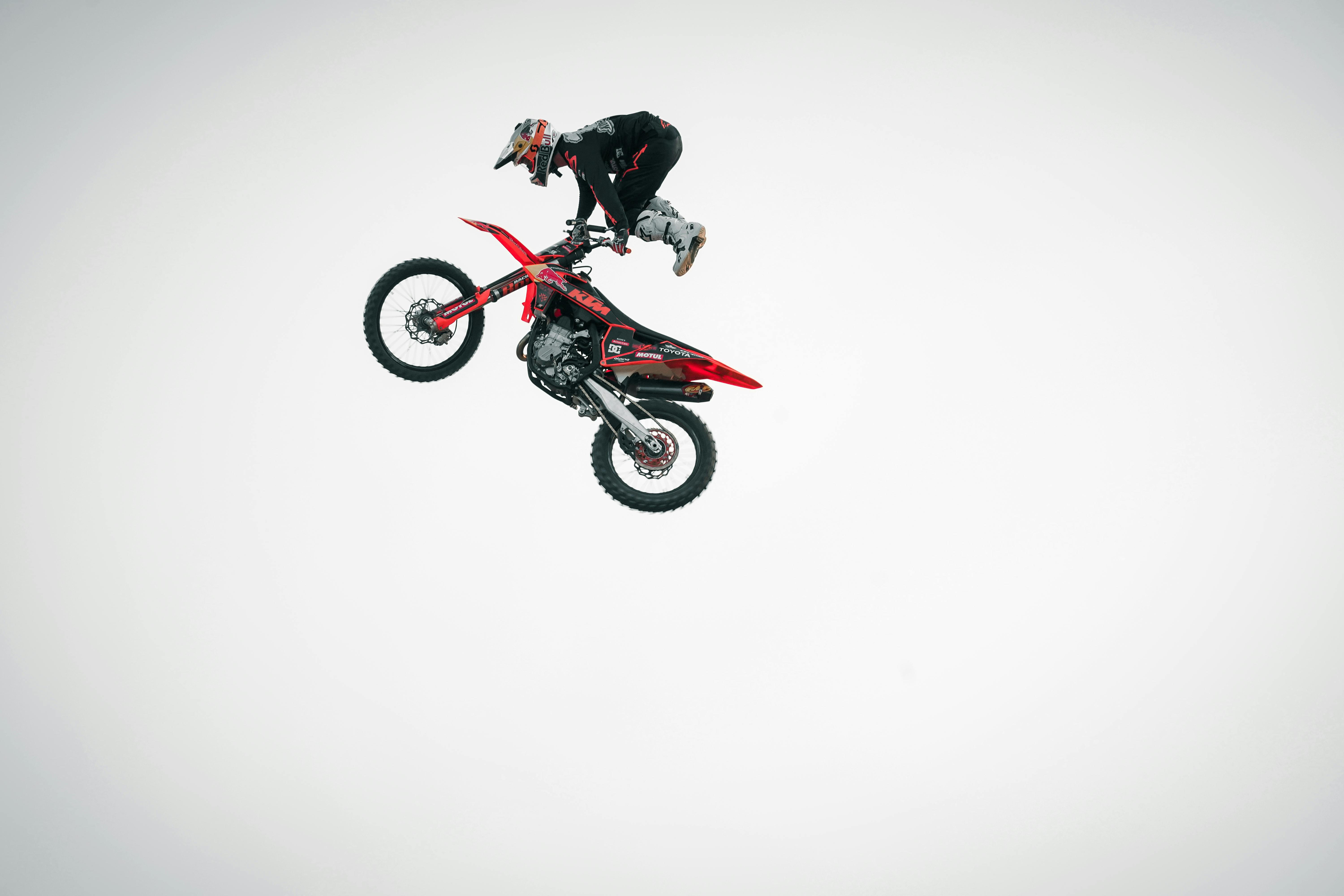 Foto Hombre en traje de motocicleta negro y rojo montando motocross moto de  cross – Imagen Rueda gratis en Unsplash