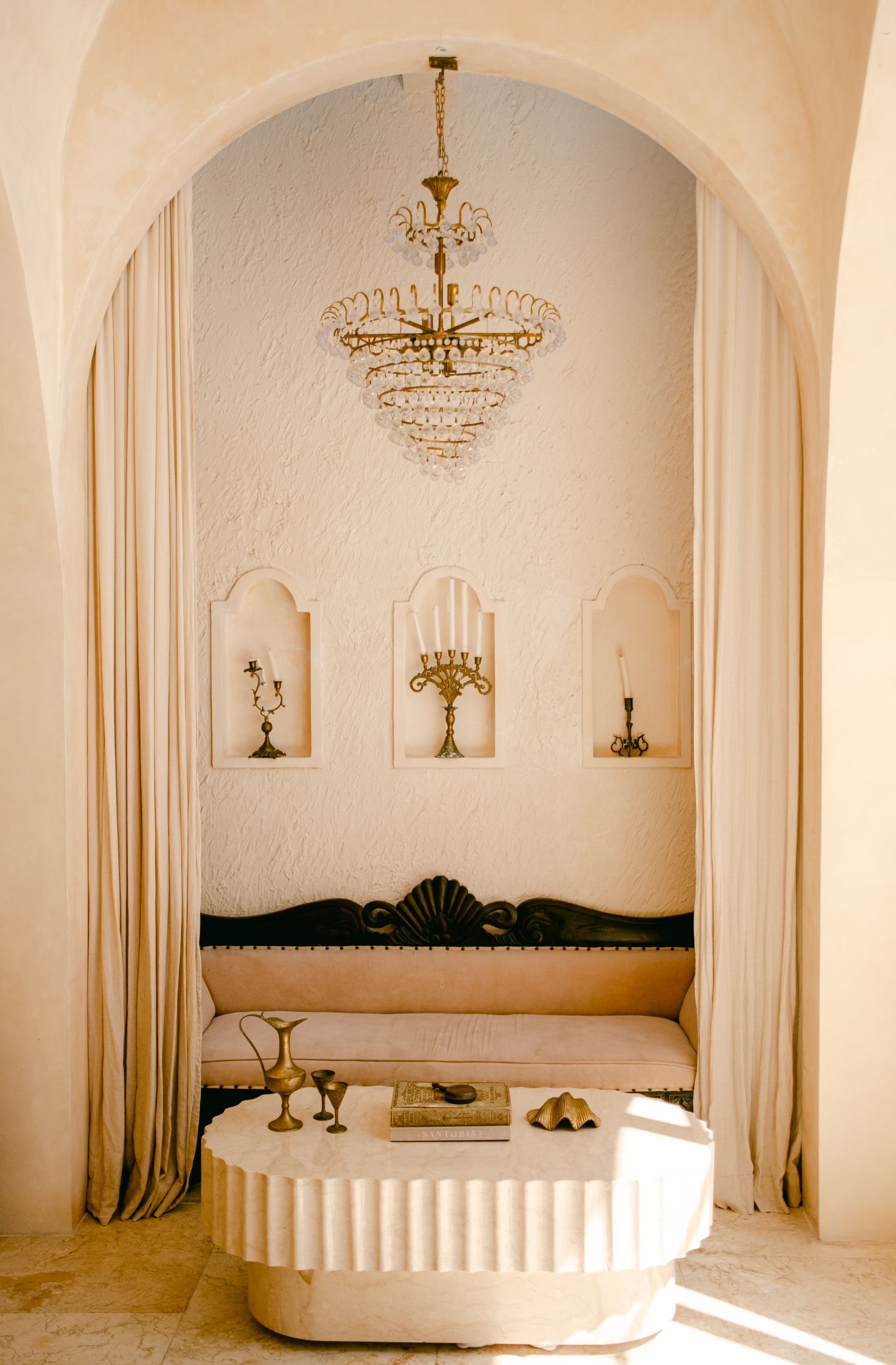 Elegant interior showcasing vintage decor and warm beige tones, featuring a chandelier and ornate furniture