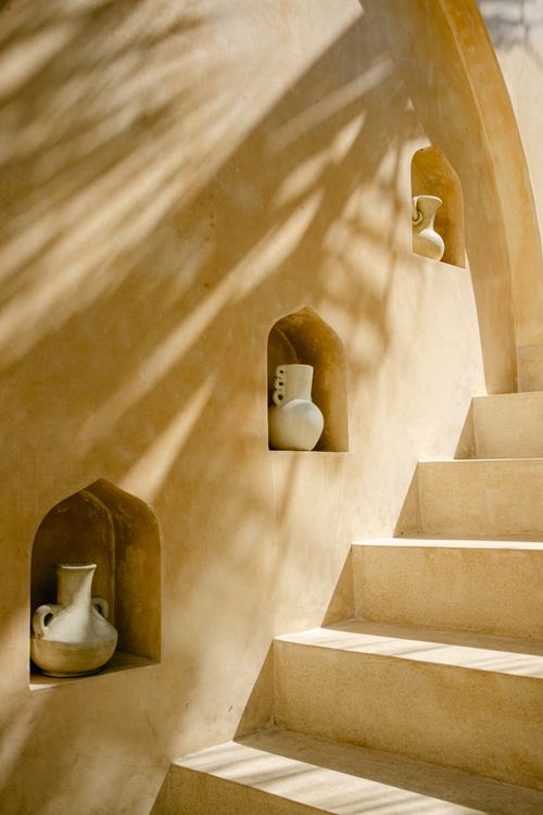 Free A minimalist staircase with ceramic jugs in an artistic setting, emphasizing natural sunlight and shadows. Stock Photo
