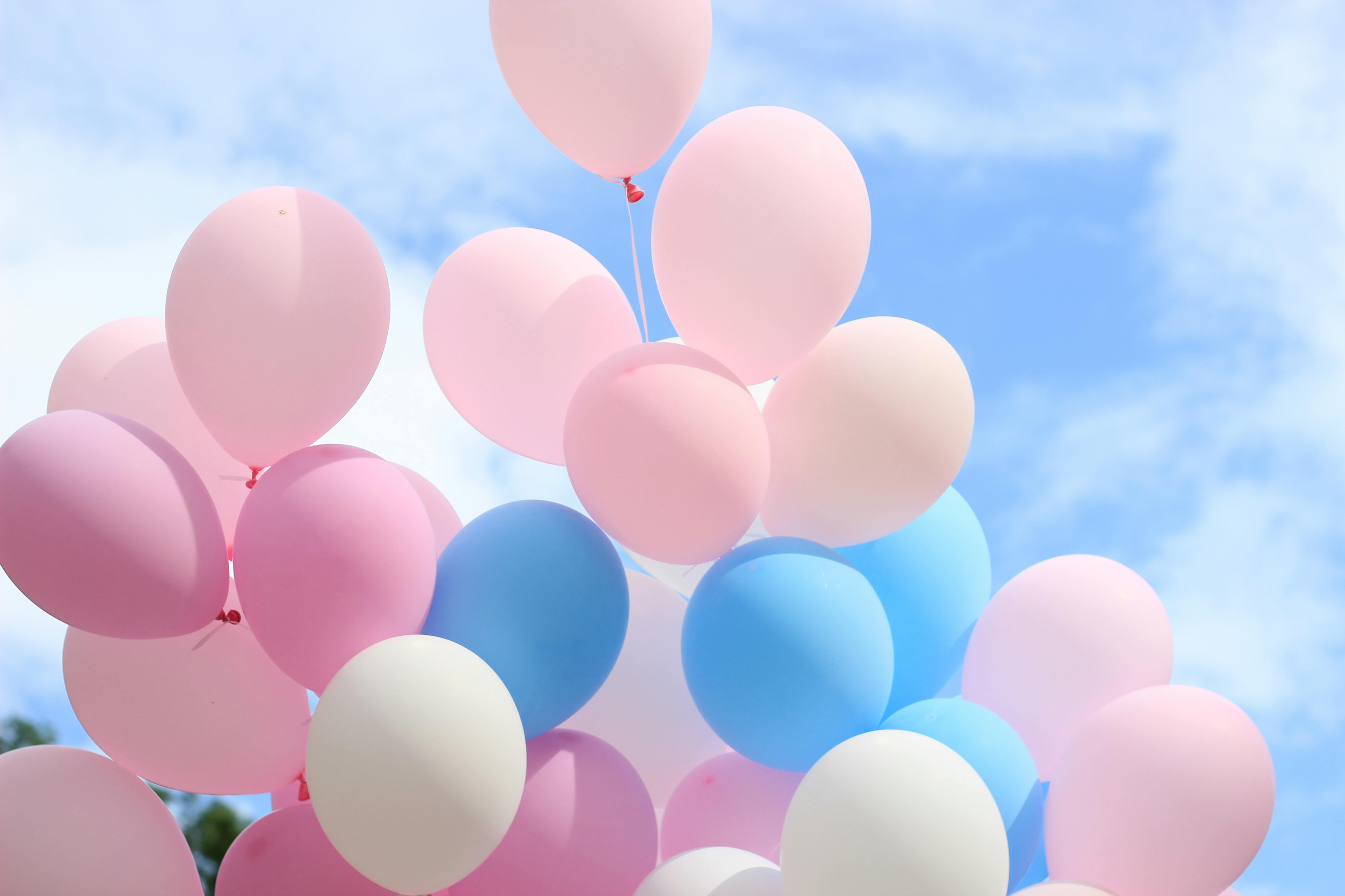 Bright pastel balloons drifting against a clear blue sky. Perfect for celebrations.