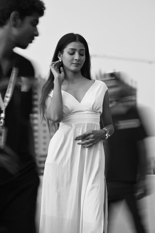 Free A stylish woman in a flowing white dress amidst city bustle, black and white. Stock Photo