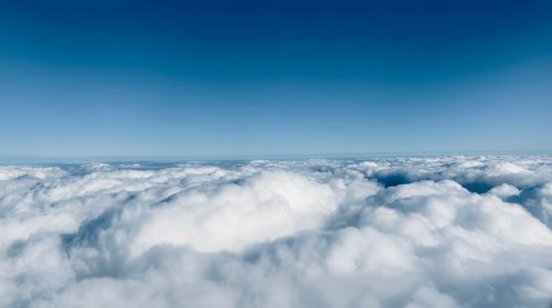 Free Breathtaking aerial view of fluffy white clouds beneath a clear blue sky. Stock Photo