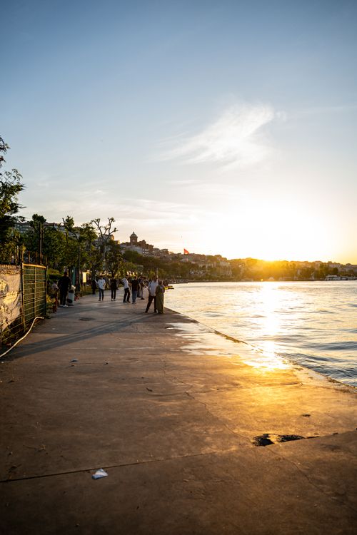 Free A picturesque sunset view over the Bosphorus with people strolling along the quay in Istanbul. Stock Photo