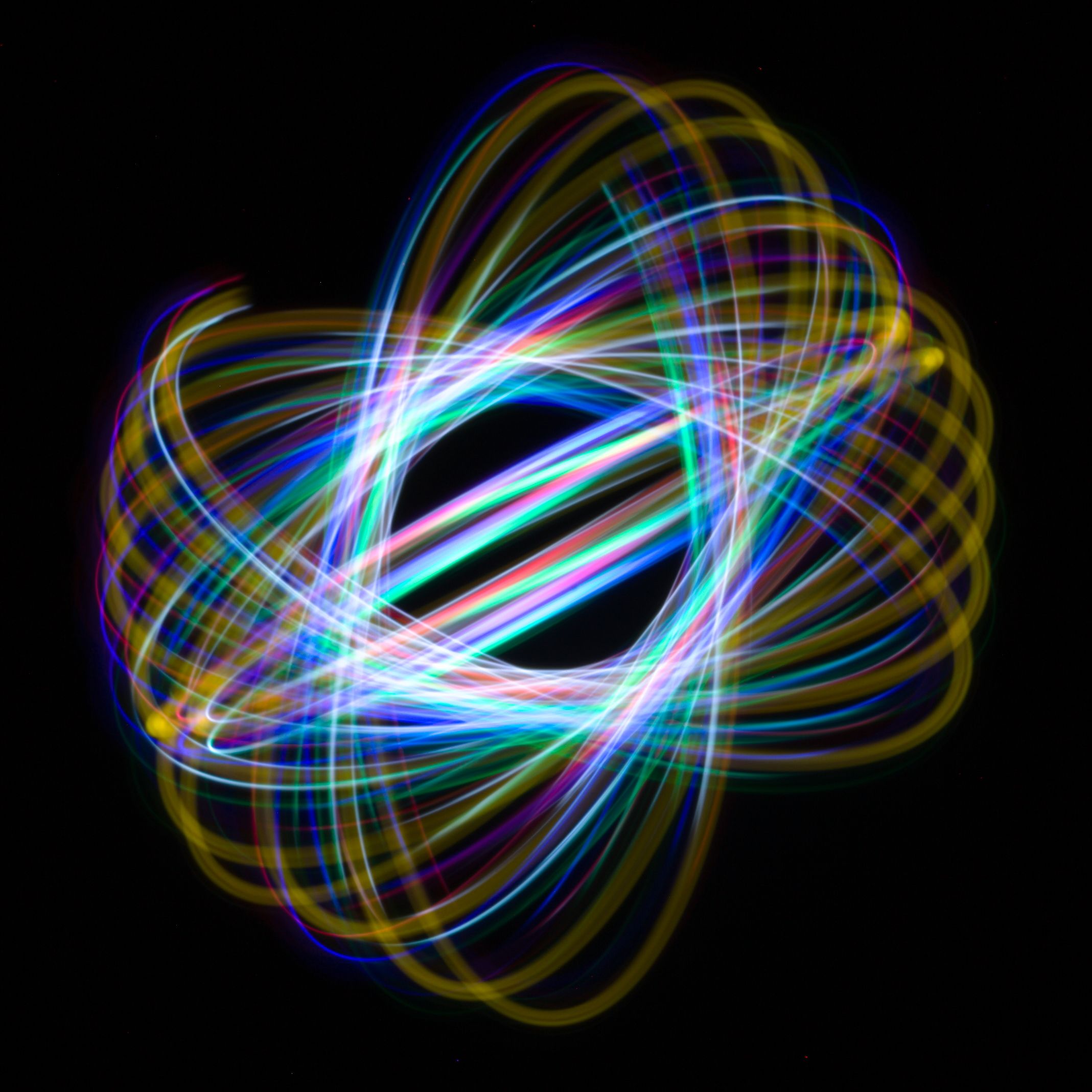 Light painting with intertwining neon trails on black — photo by Fabrizzio Alo on Pexels