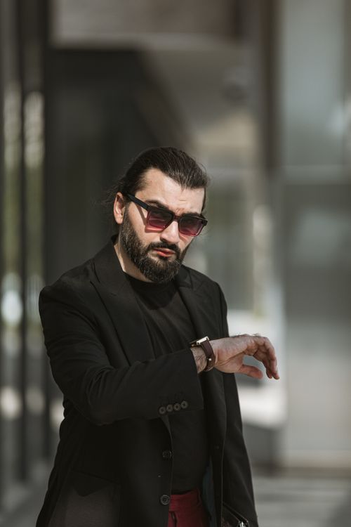 Free Bearded man in black sunglasses and suit gestures outdoors in Baku, Azerbaijan. Stock Photo