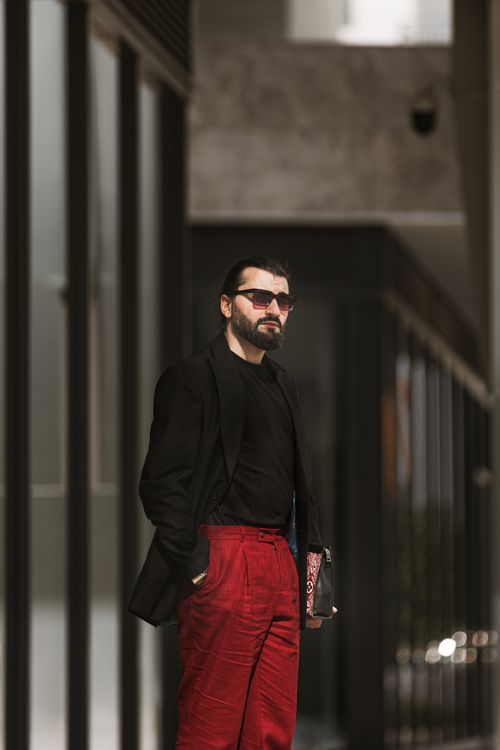 Free Fashionable man with sunglasses and red pants posing in a modern setting in Baku, Azerbaijan. Stock Photo