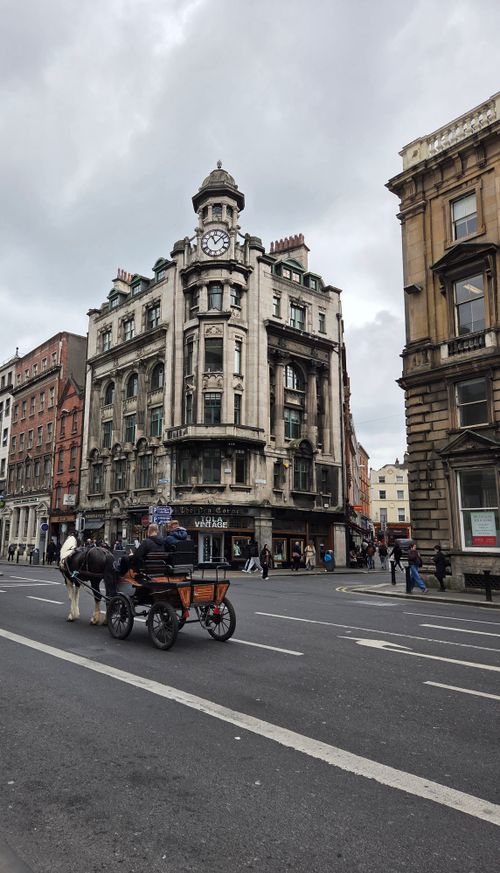 Free Elegant historical building in city with horse-drawn carriage on street. Stock Photo