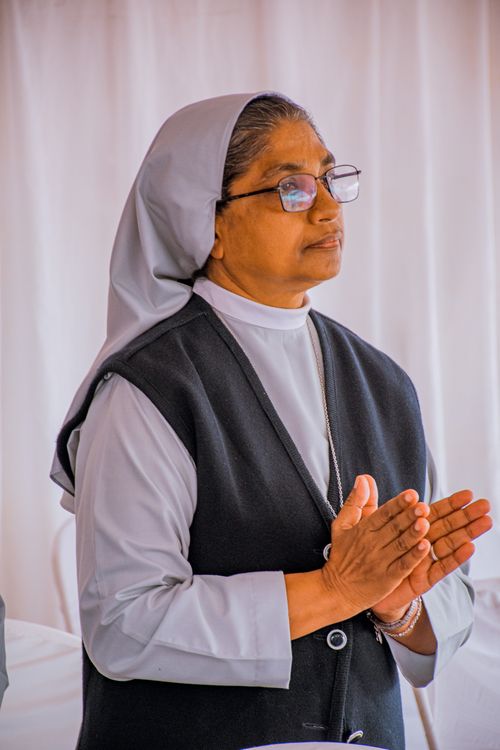 Free A nun standing indoors with hands clasped in a prayerful pose, expressing devotion. Stock Photo