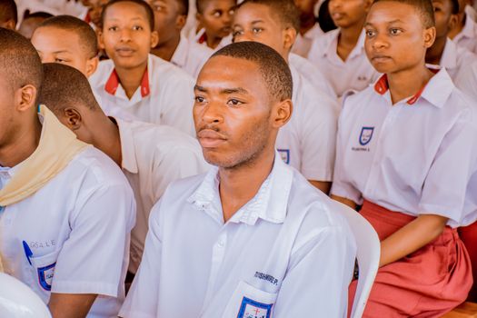 A group of students attending a lecture wearing school uniforms, focused and attentive.
