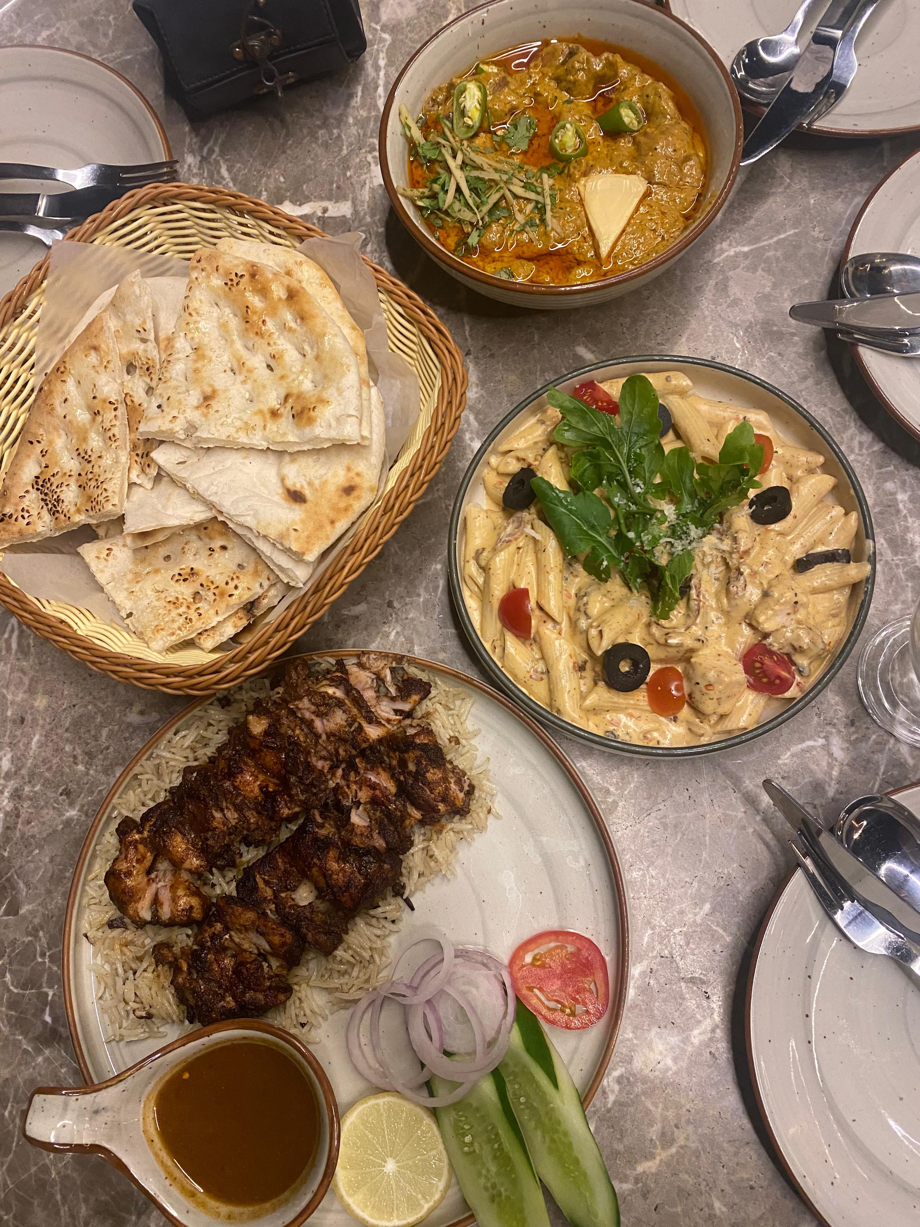 A delectable spread of Pakistani dishes including naan, curry, pasta, and barbecue in Karachi.