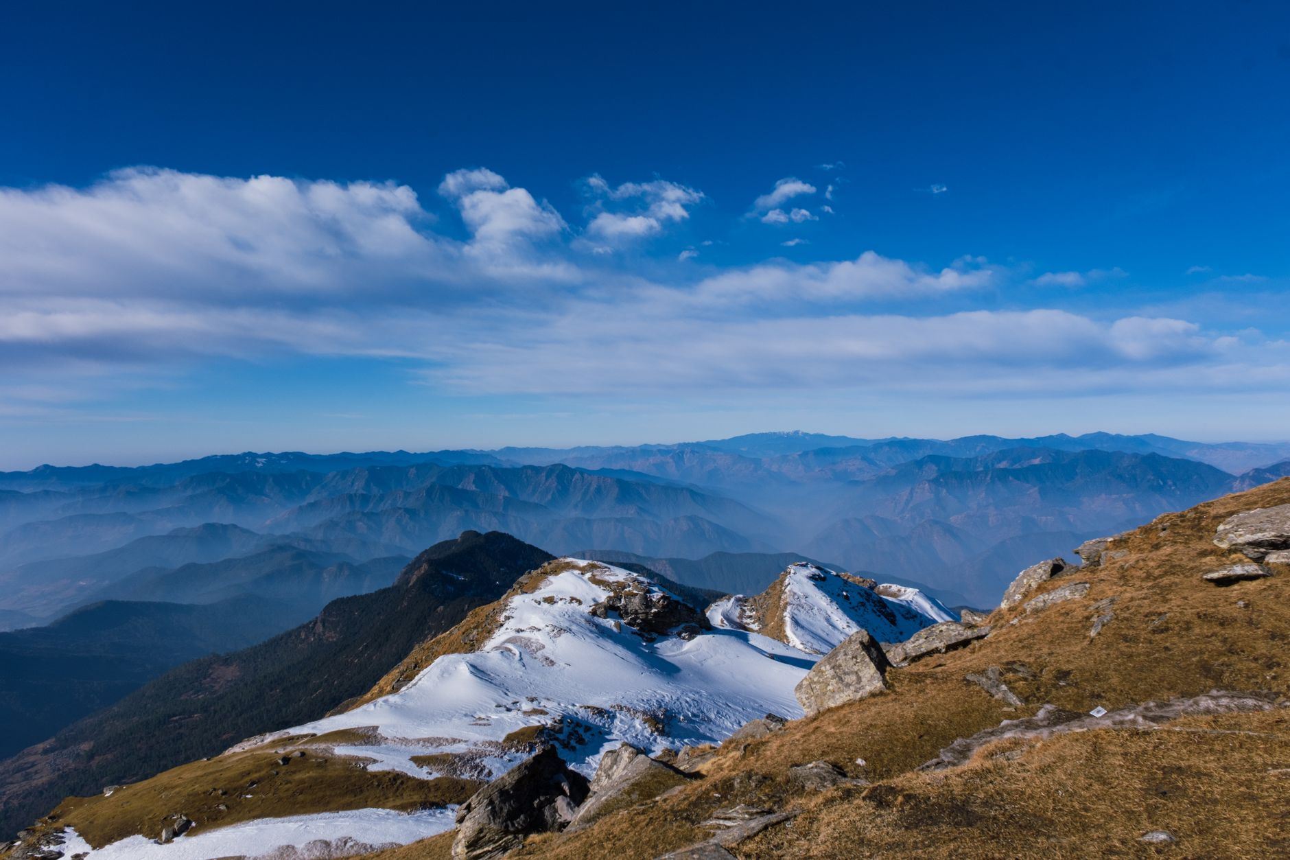 Snow-capped peaks of Singtur Range under clear blue sky, showcasing the beauty of Uttarakhand's natural landscape.