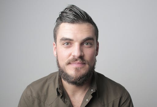 一个留着胡须、发型利落的男人，面带温暖笑容的特写肖像