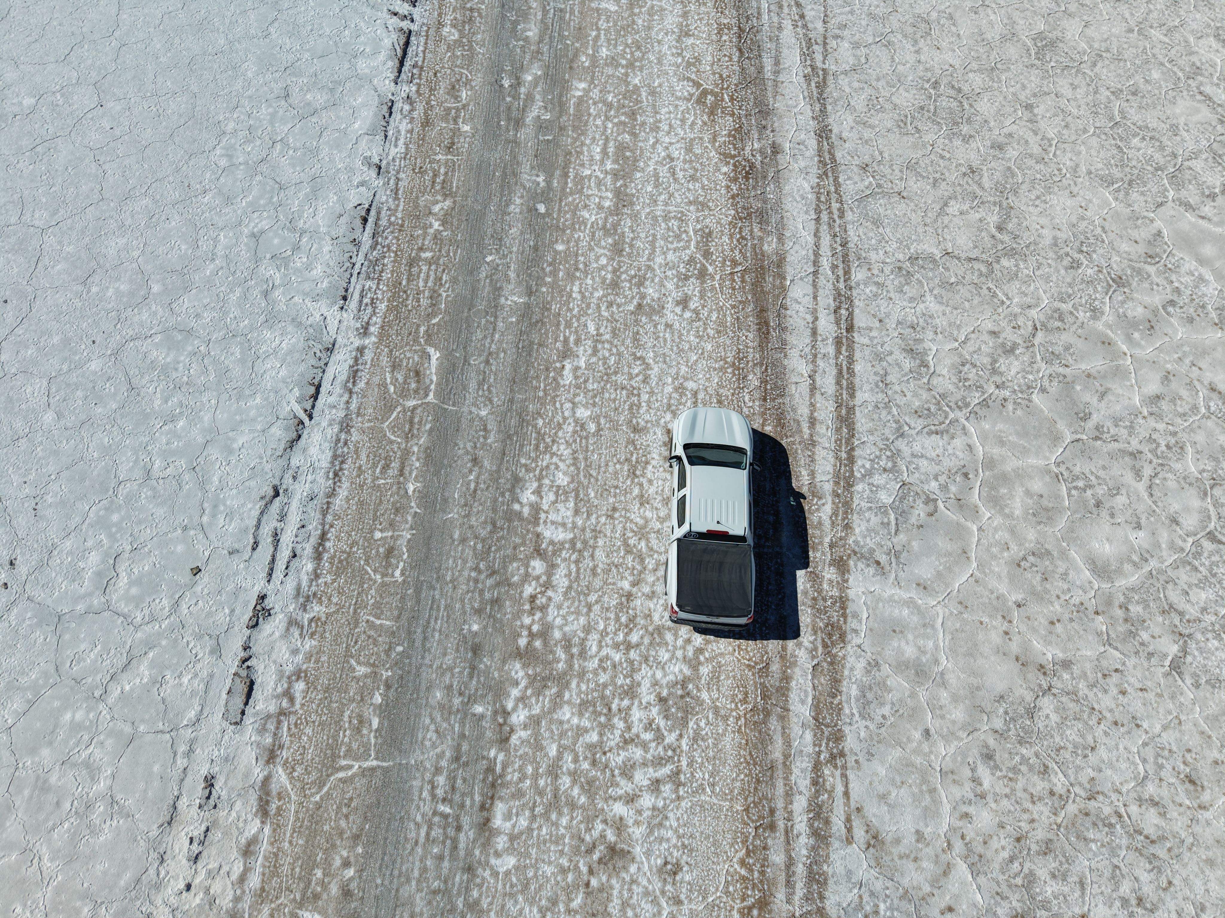 Vehicle traveling on snow-covered road treated with road salt