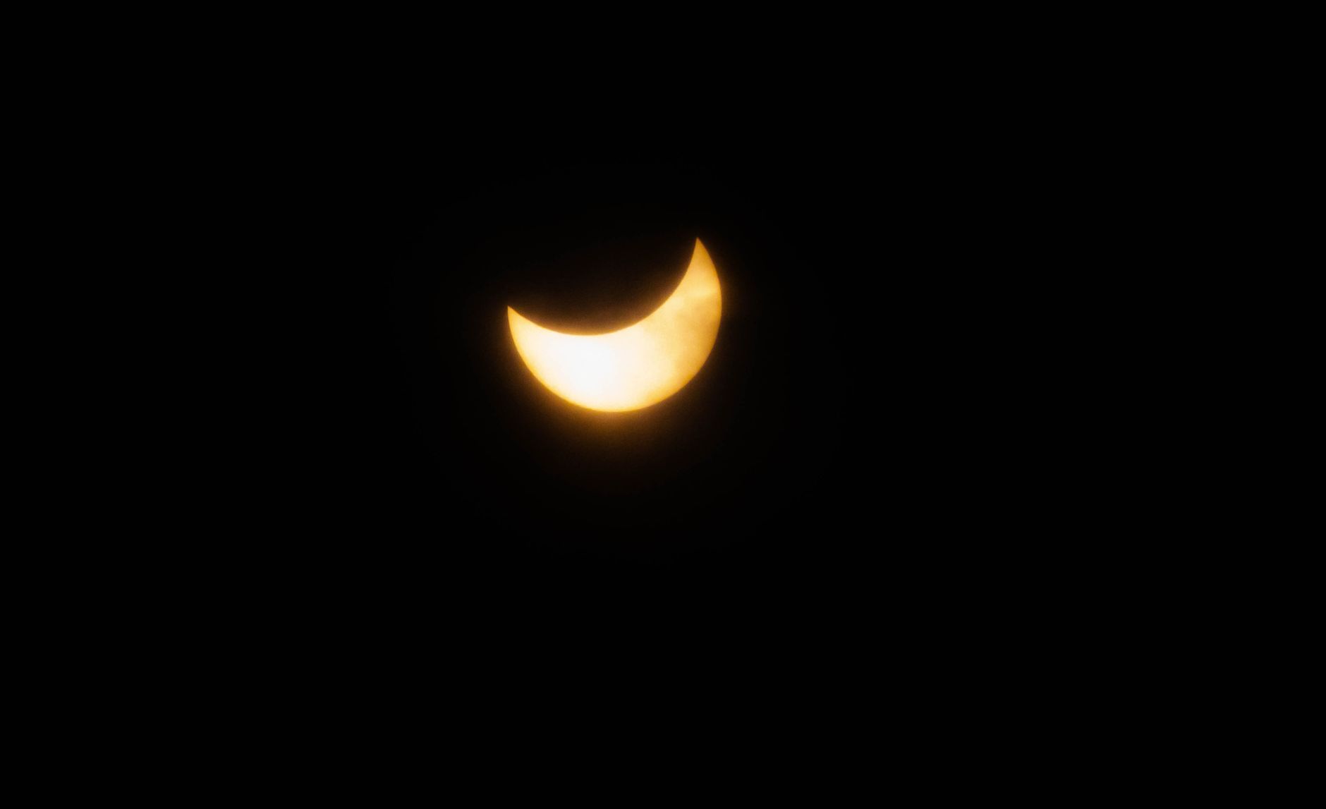 Een fascinerend beeld van een sikkelvormige zonsverduistering tegen een pikzwarte hemel, die de hemelse schoonheid benadrukt.