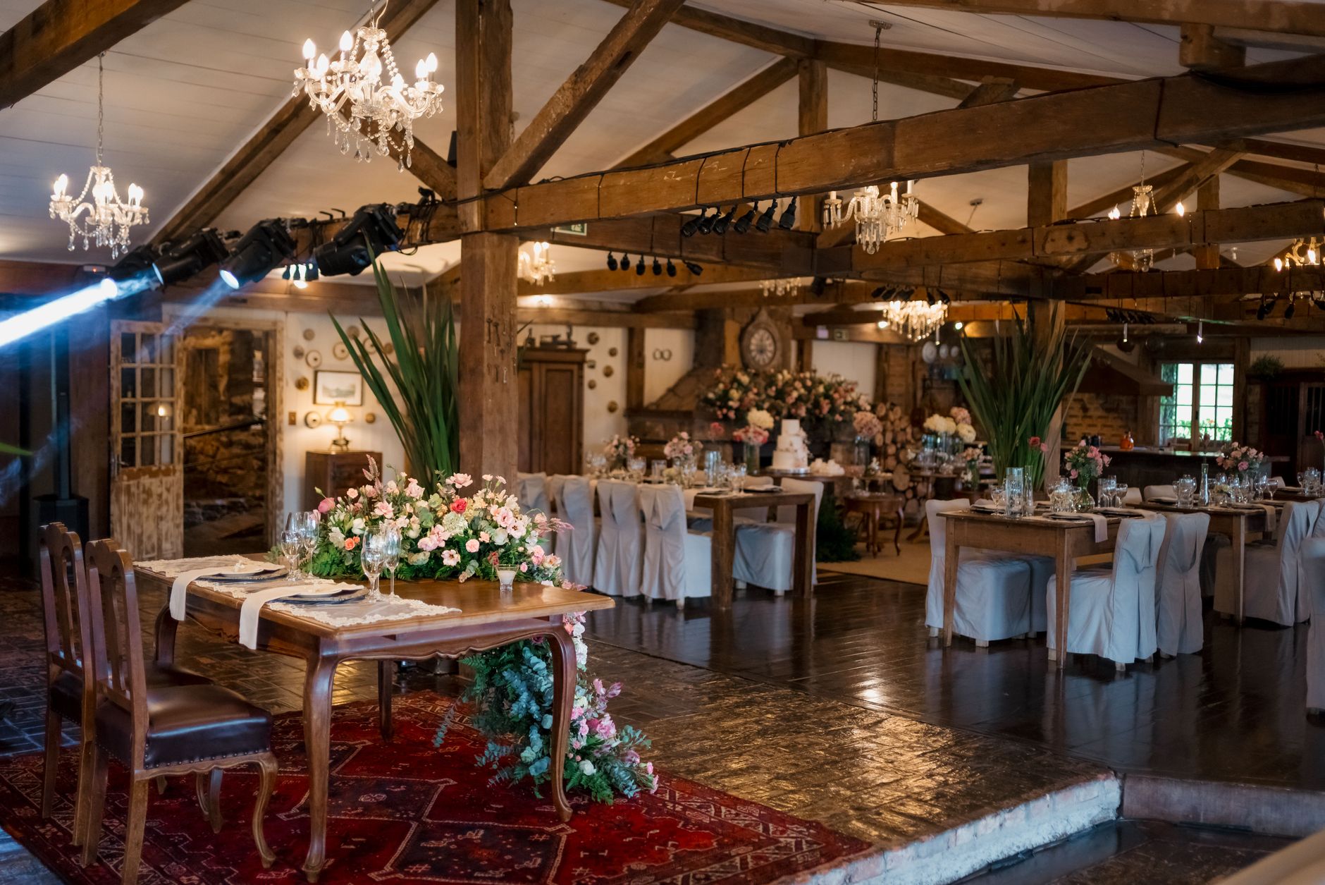Beautiful rustic wedding reception with elegant floral arrangements and romantic lighting indoors.