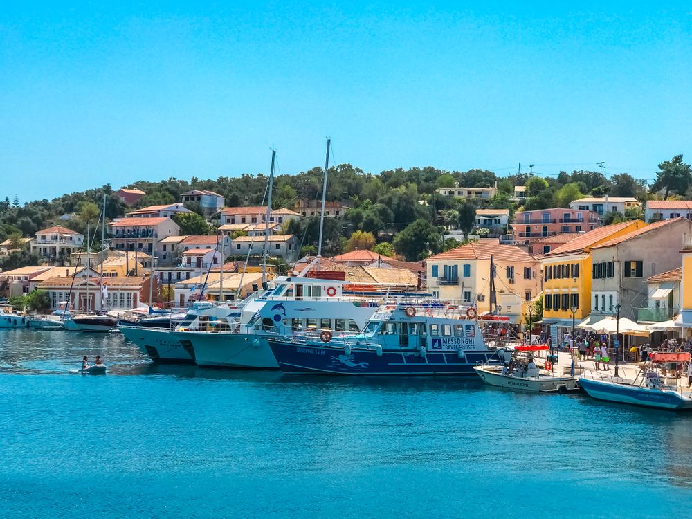 Faleză cu bărci și case colorate într-un sat de pe malul mării din Kefalonia