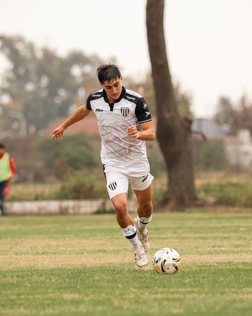 Free Teenage soccer player in action on a natural grass pitch during a daytime match. Stock Photo
