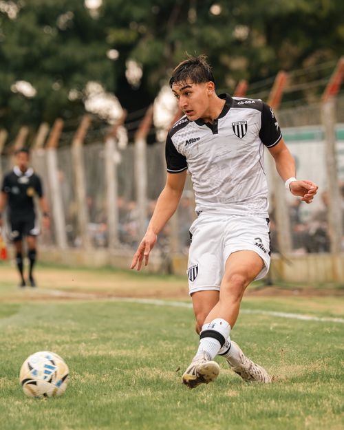 Free Young soccer player kicking ball on field during game. Stock Photo