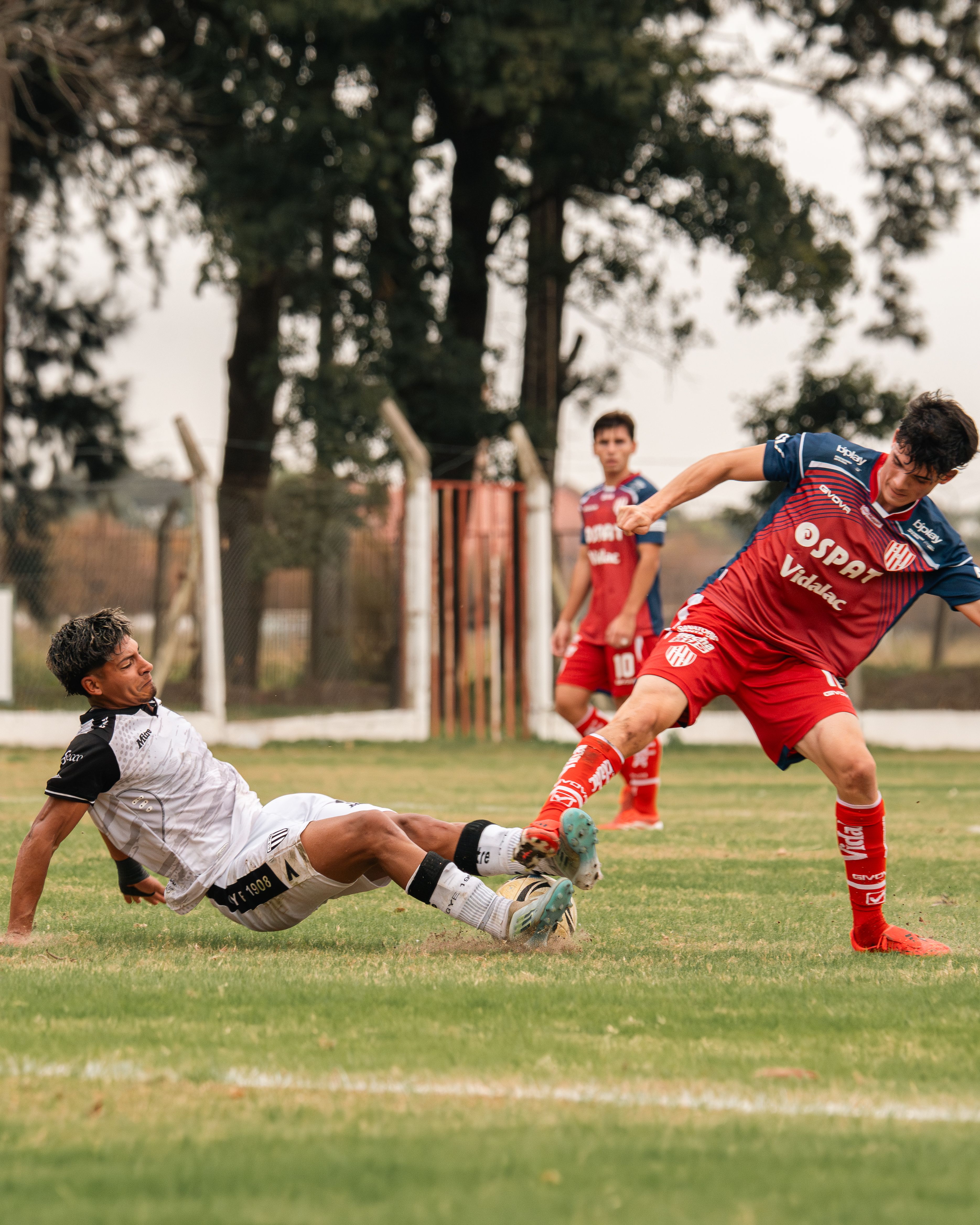 De franc Captura d'un partit de futbol intens amb jugadors fent una entrada dramàtica al camp. Foto d'estoc