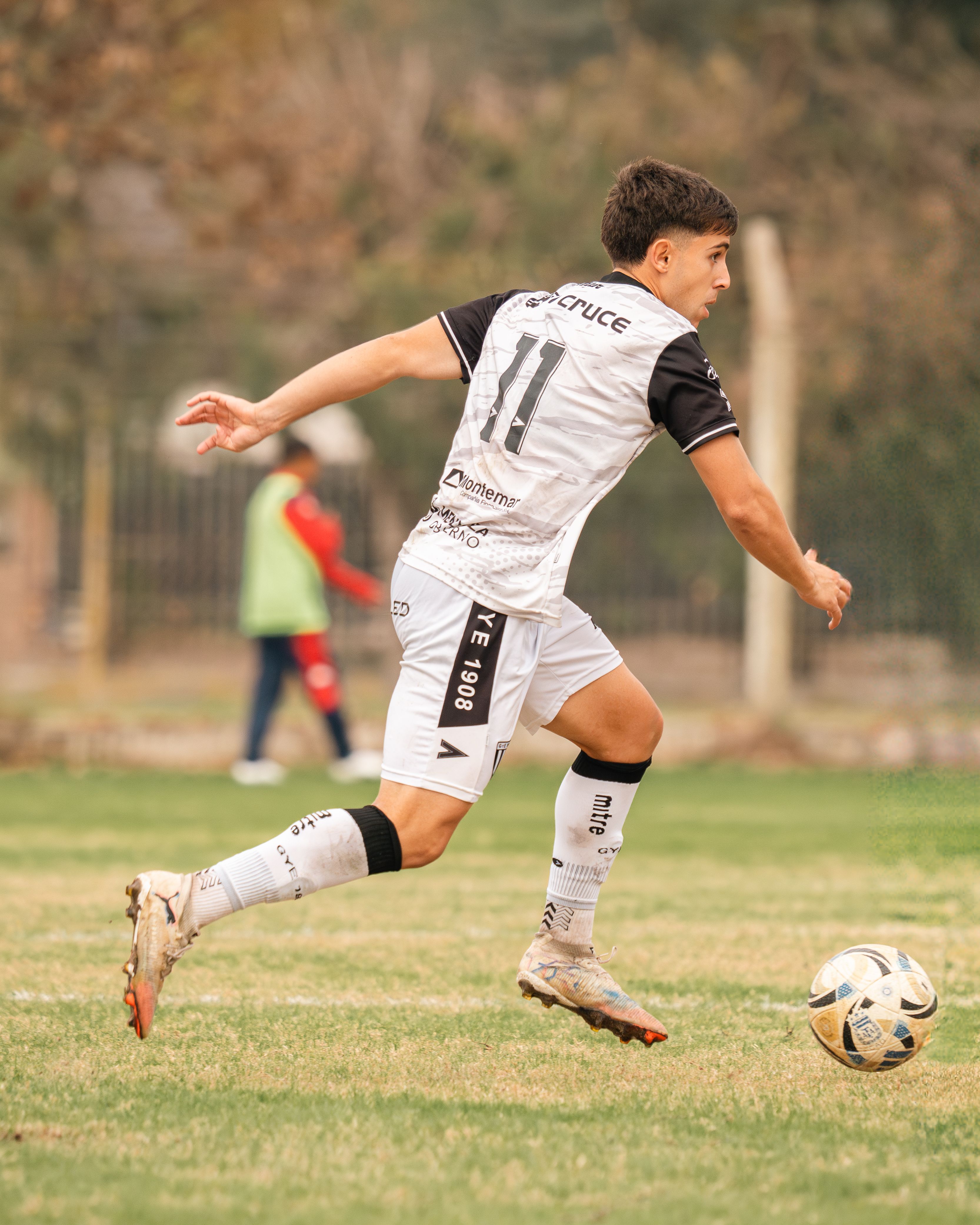 Soccer player in action on field with blurred background, capturing mid-movement energy.